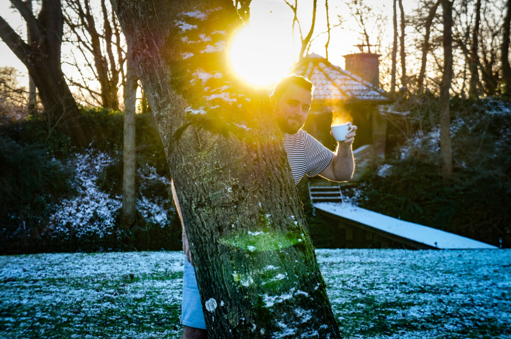 Theo Steneker, NLP trainer, ontspannen met een kop koffie en een glimlach.